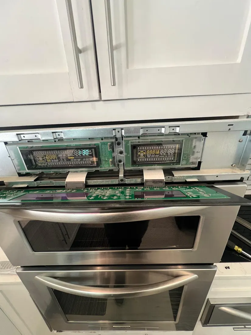 Wall oven control panel opened for service