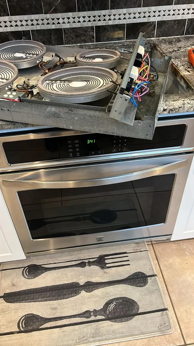 Electric cooktop opened for service